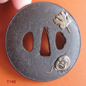 T146. Iron tsuba with Okame and fan